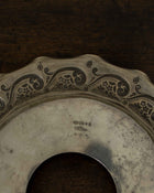 Decorative metal object with engraved patterns on a wooden surface