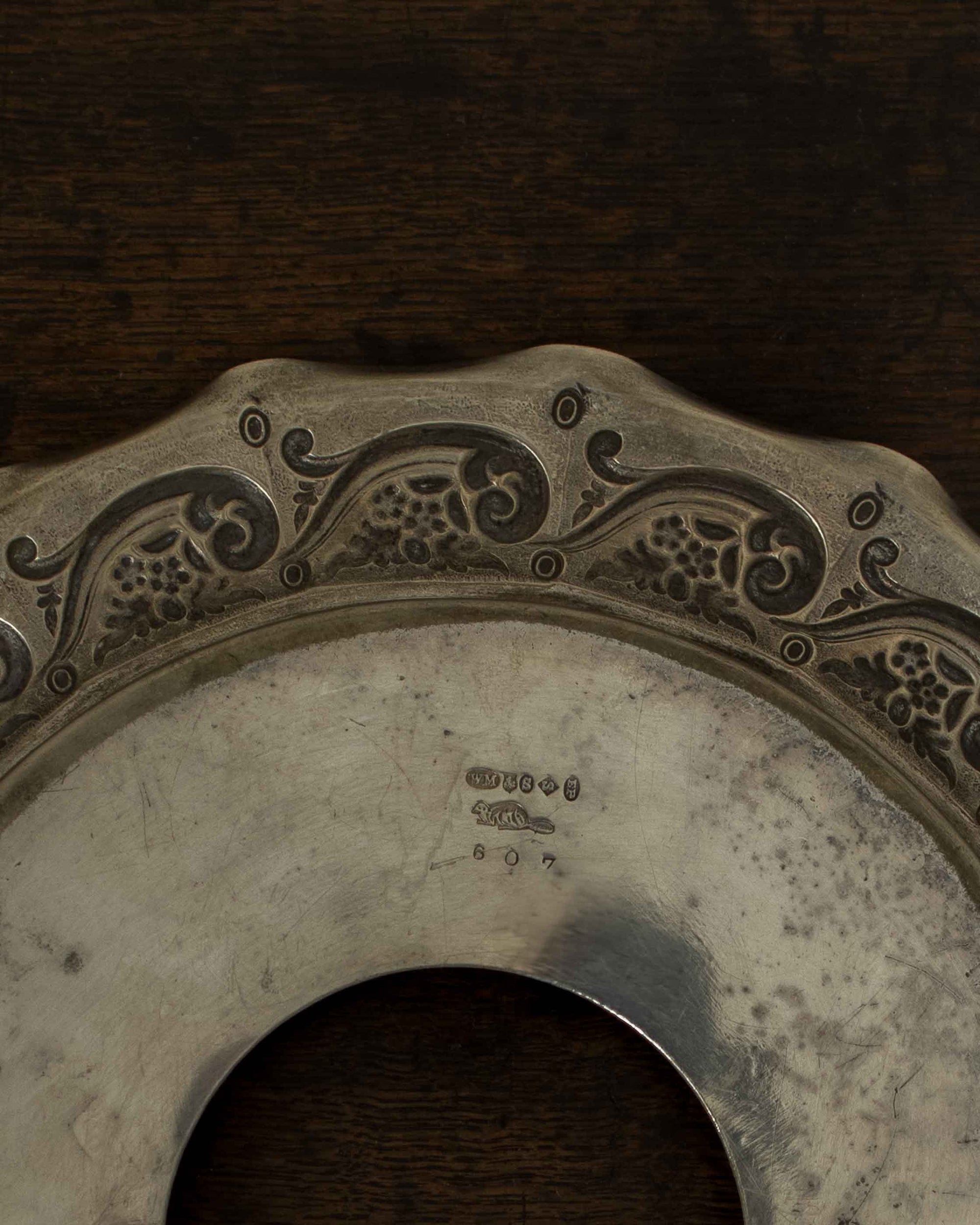 Decorative metal object with engraved patterns on a wooden surface