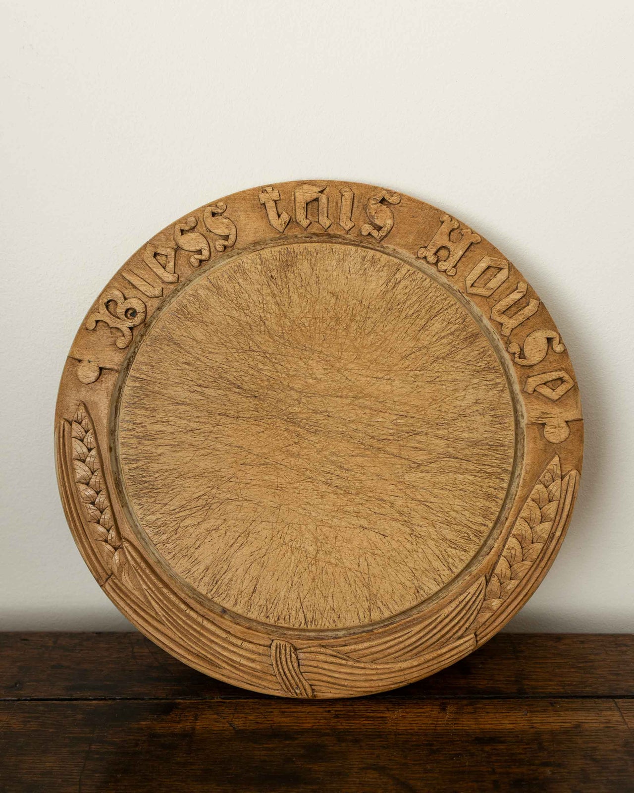 Wooden breadboard with carved text on a wooden surface