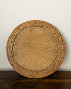 Wooden breadboard with carved text on a wooden surface