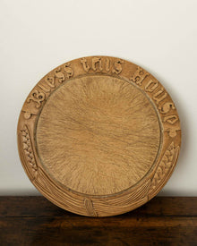Wooden breadboard with carved text on a wooden surface