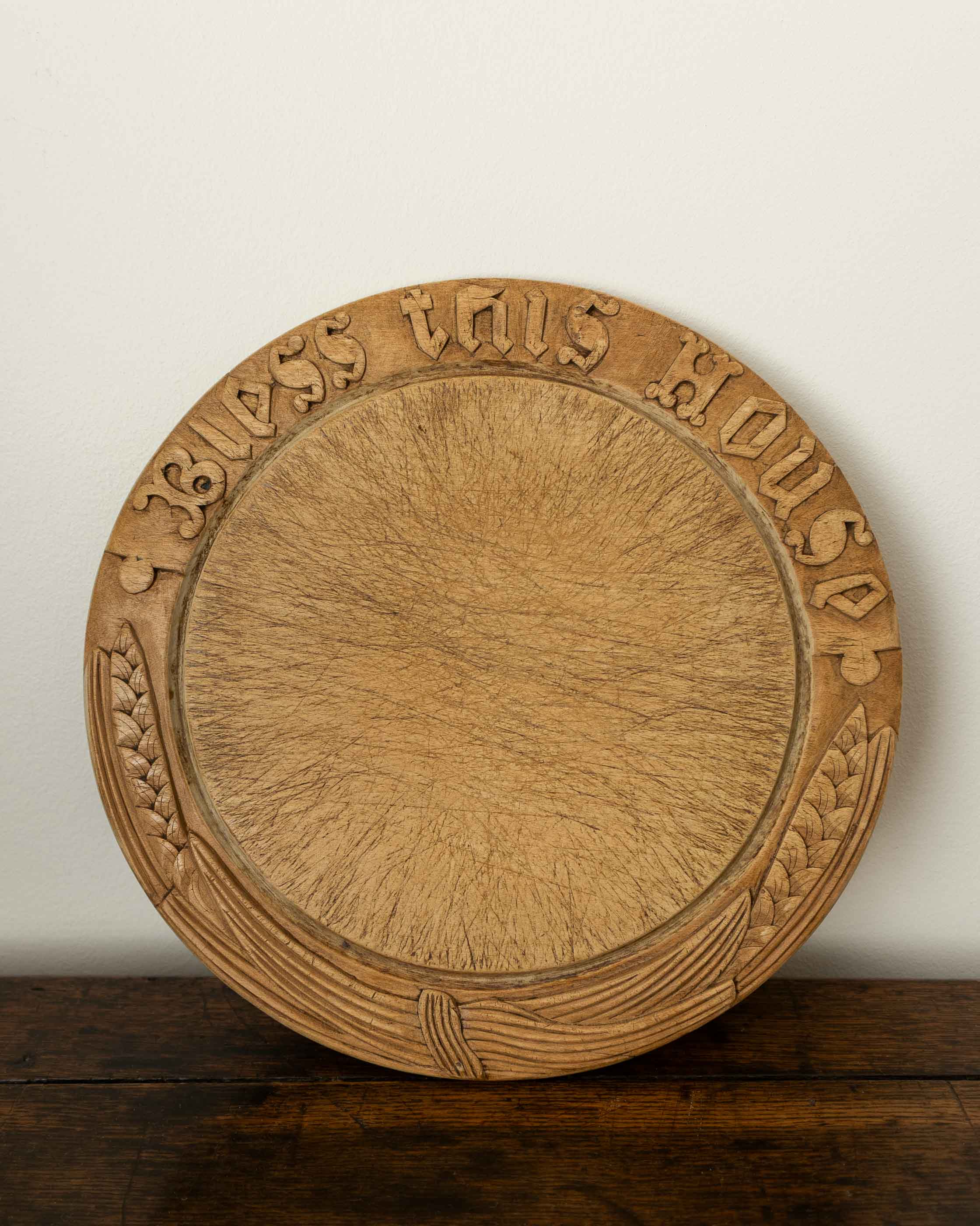 Wooden breadboard with carved text on a wooden surface