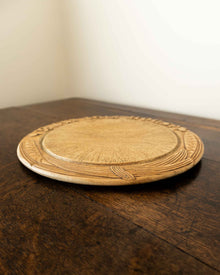Wooden breadboard with carved text on a wooden surface