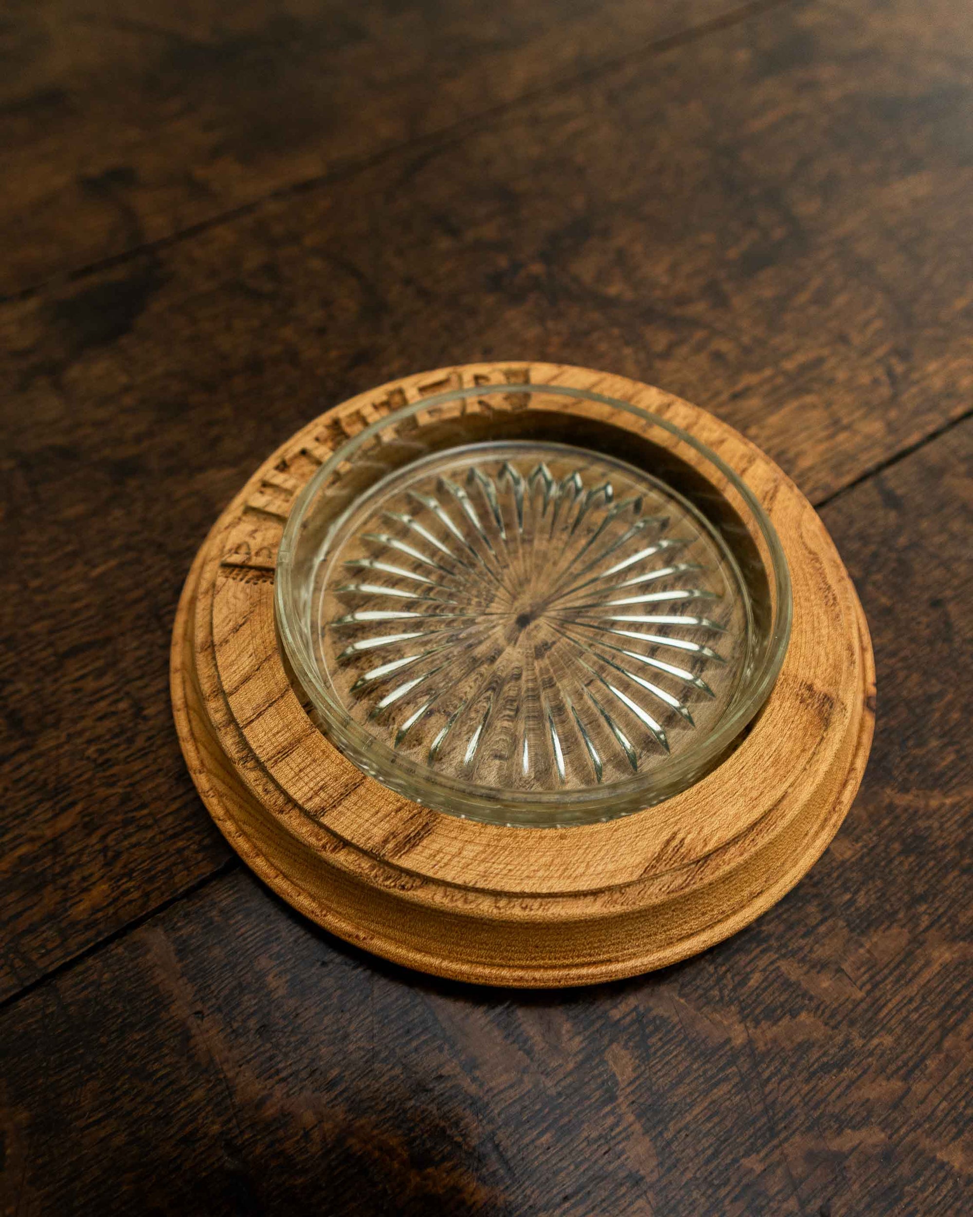 Wooden butter dish with a glass insert on a wooden surface