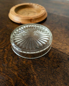 Wooden butter dish with a glass insert on a wooden surface