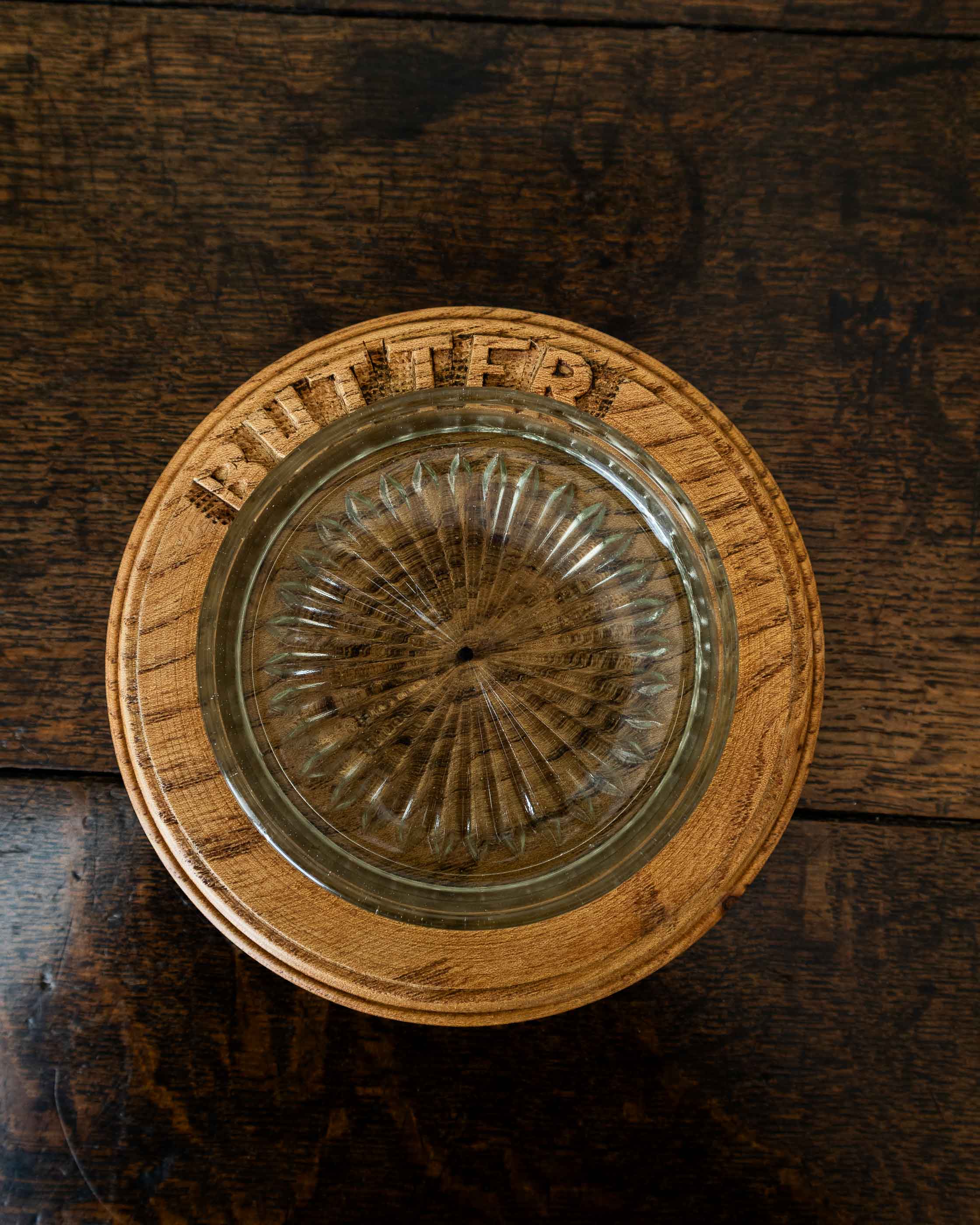 Wooden butter dish with a glass insert on a wooden surface