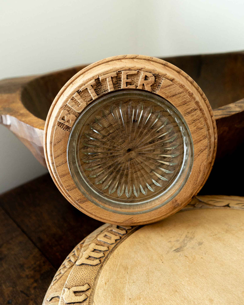 Wooden butter dish with a glass insert on a wooden surface