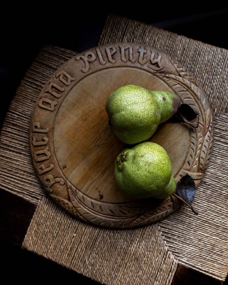 Two green pears on a wooden breadboard 
