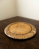 Wooden breadboard with carved text on a wooden surface