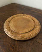 Wooden breadboard with carved text on a wooden surface