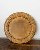 Wooden breadboard with carved text on a wooden surface