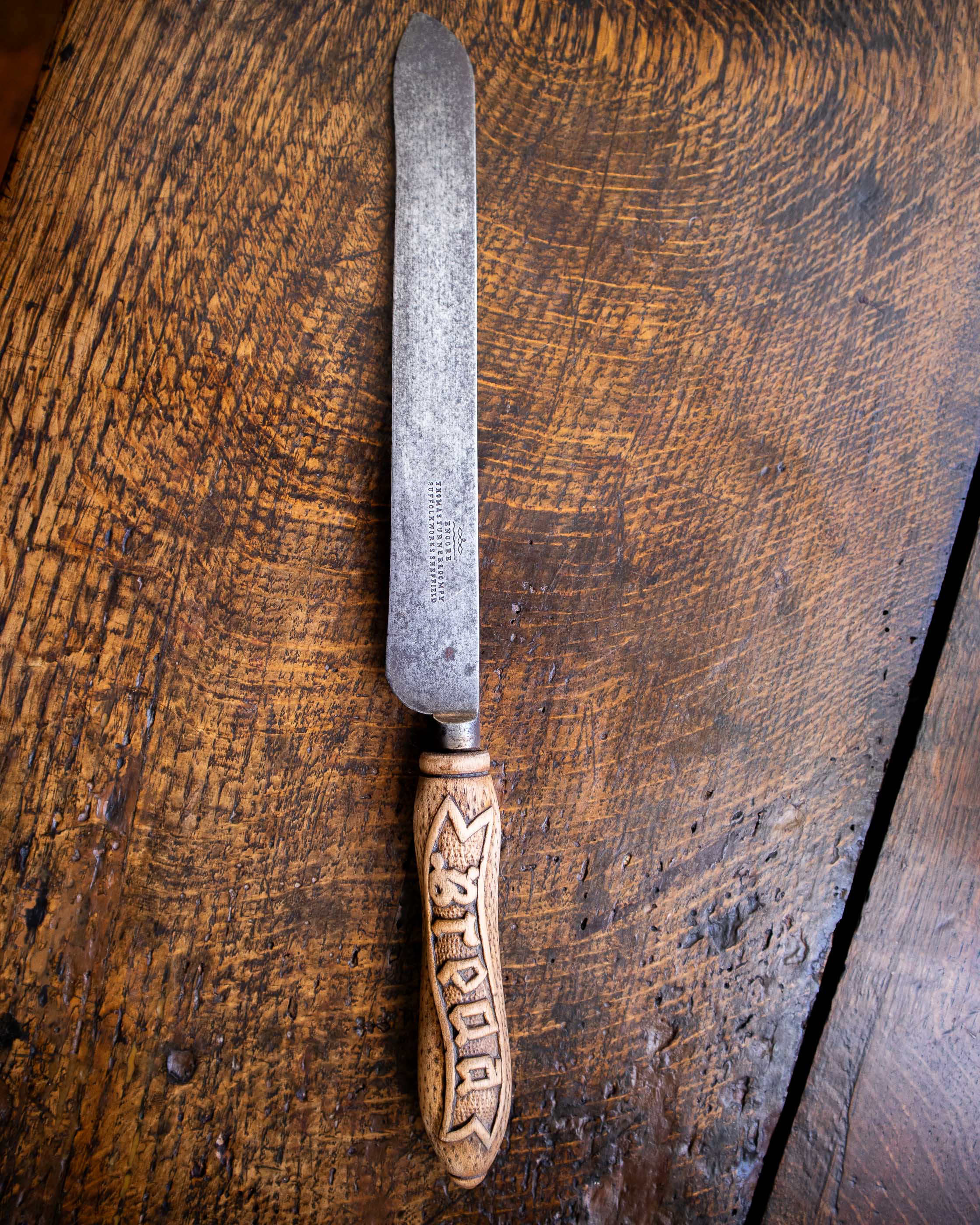 Bread knife with a decorative handle on a wooden surface