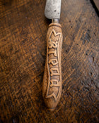Decorative knife with a wooden handle on a wooden surface