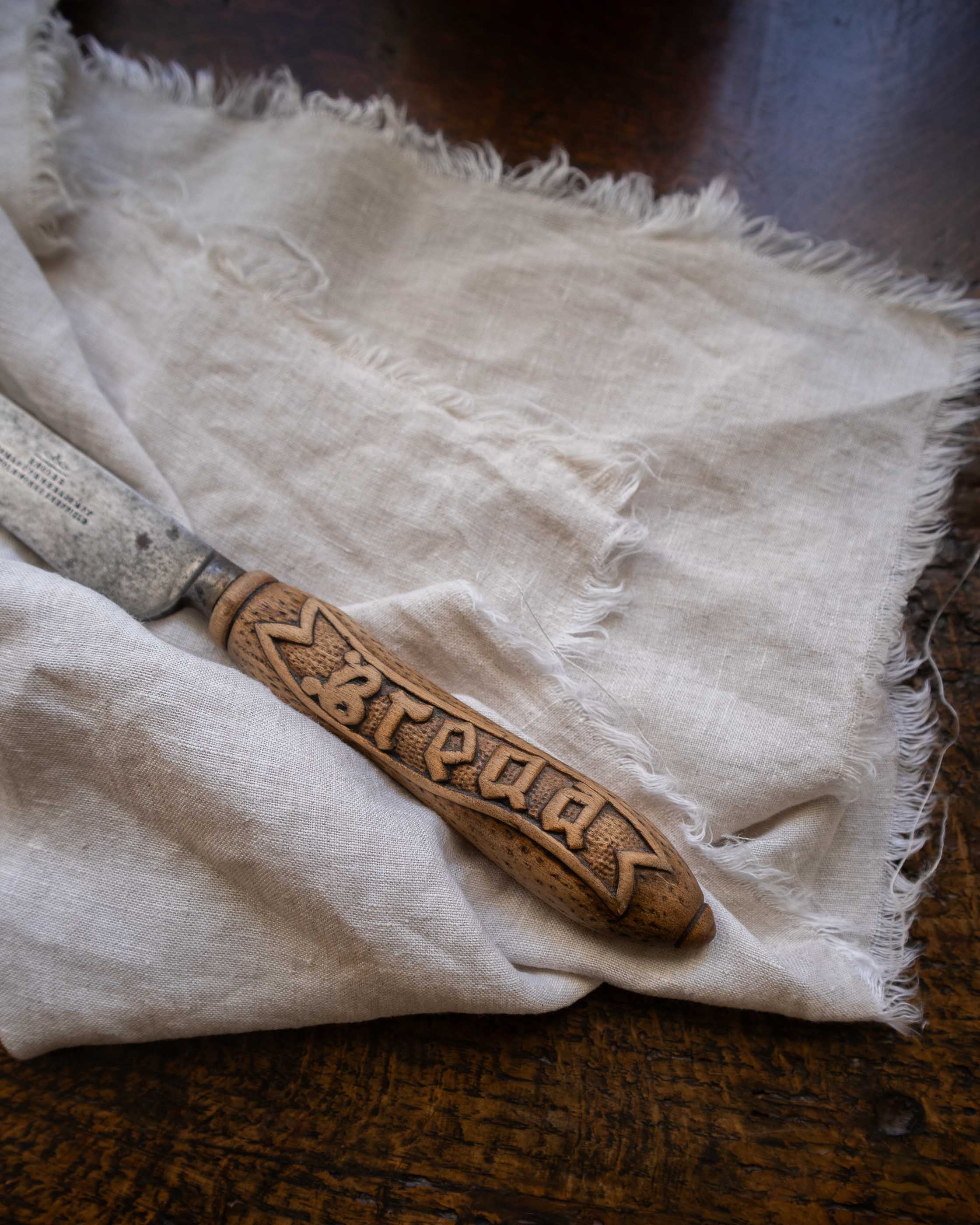 Carved wooden handle knife on a white cloth with visible text