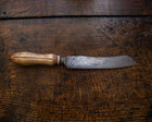 Bread knife with a wooden handle on a wooden surface