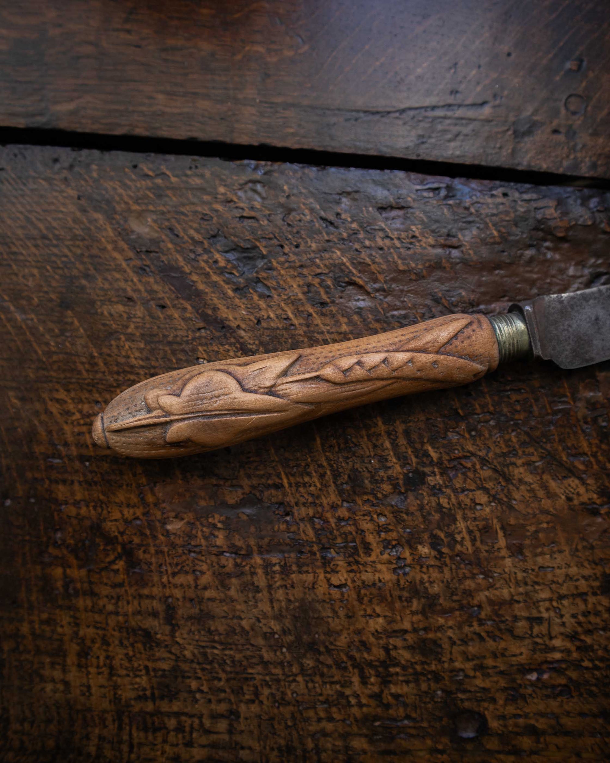 Wooden-handled knife on a dark wooden surface