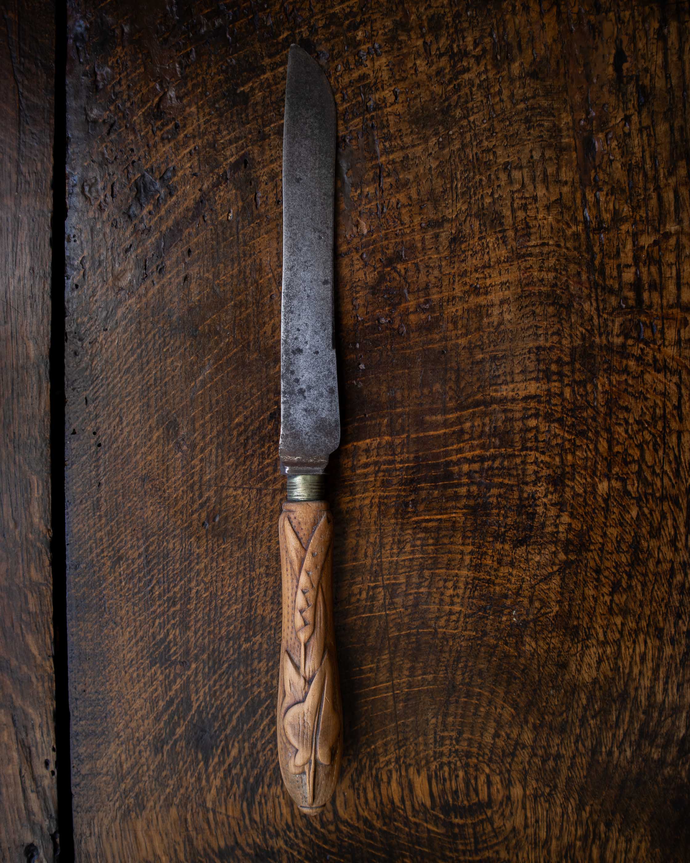 Antique knife with a wooden handle on a wooden surface