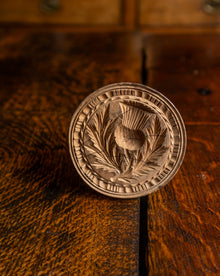 Wooden butter stamp with intricate design on a wooden surface