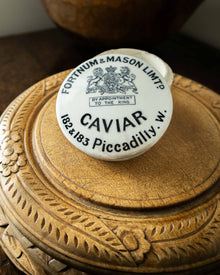 Caviar container with Fortnum & Mason label on a wooden surface