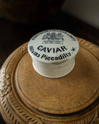 Caviar container lid with Fortnum & Mason branding on a wooden surface