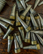 Collection of metal and brass icing tips on a wooden surface