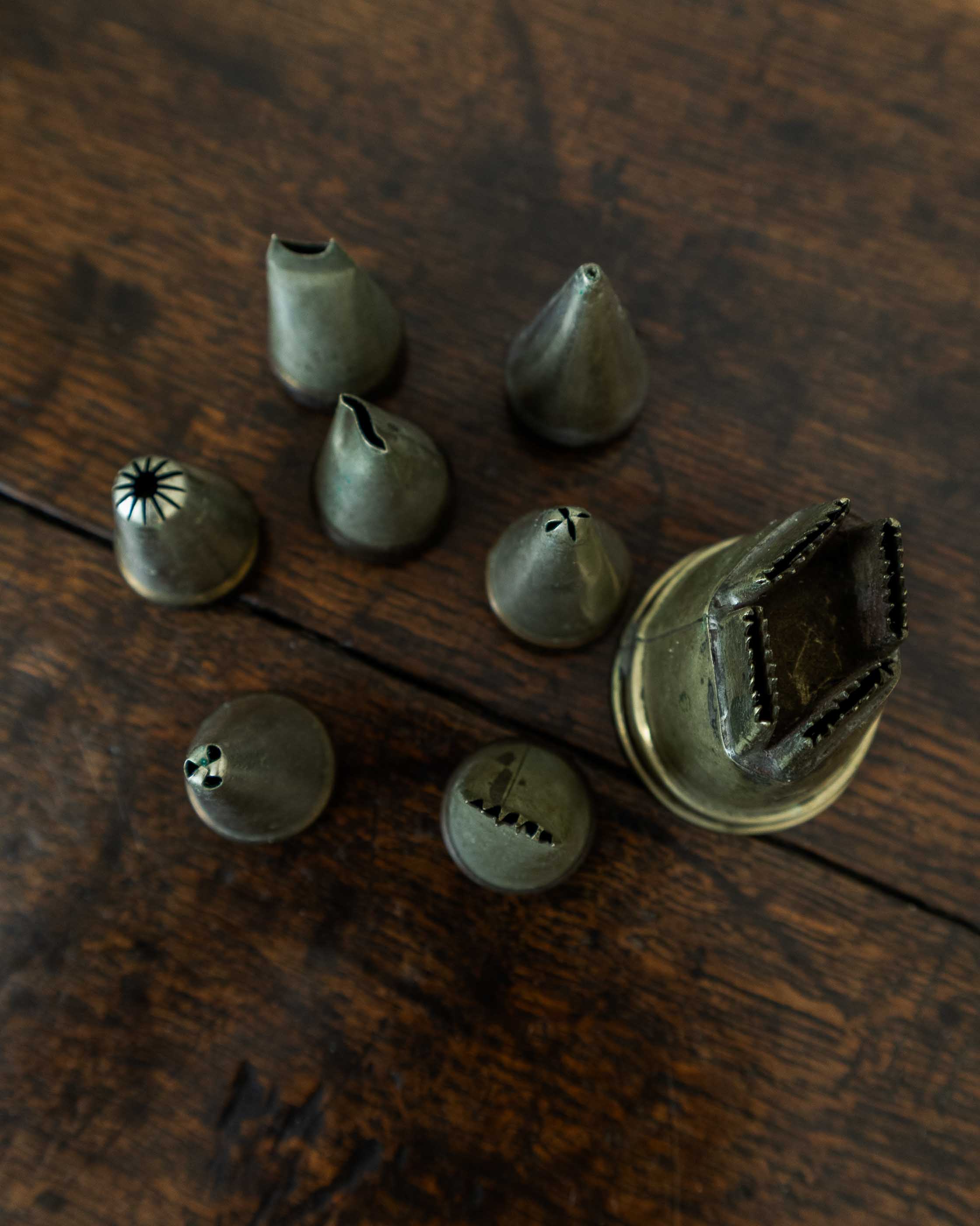 Set of metal icing nozzles on a wooden surface