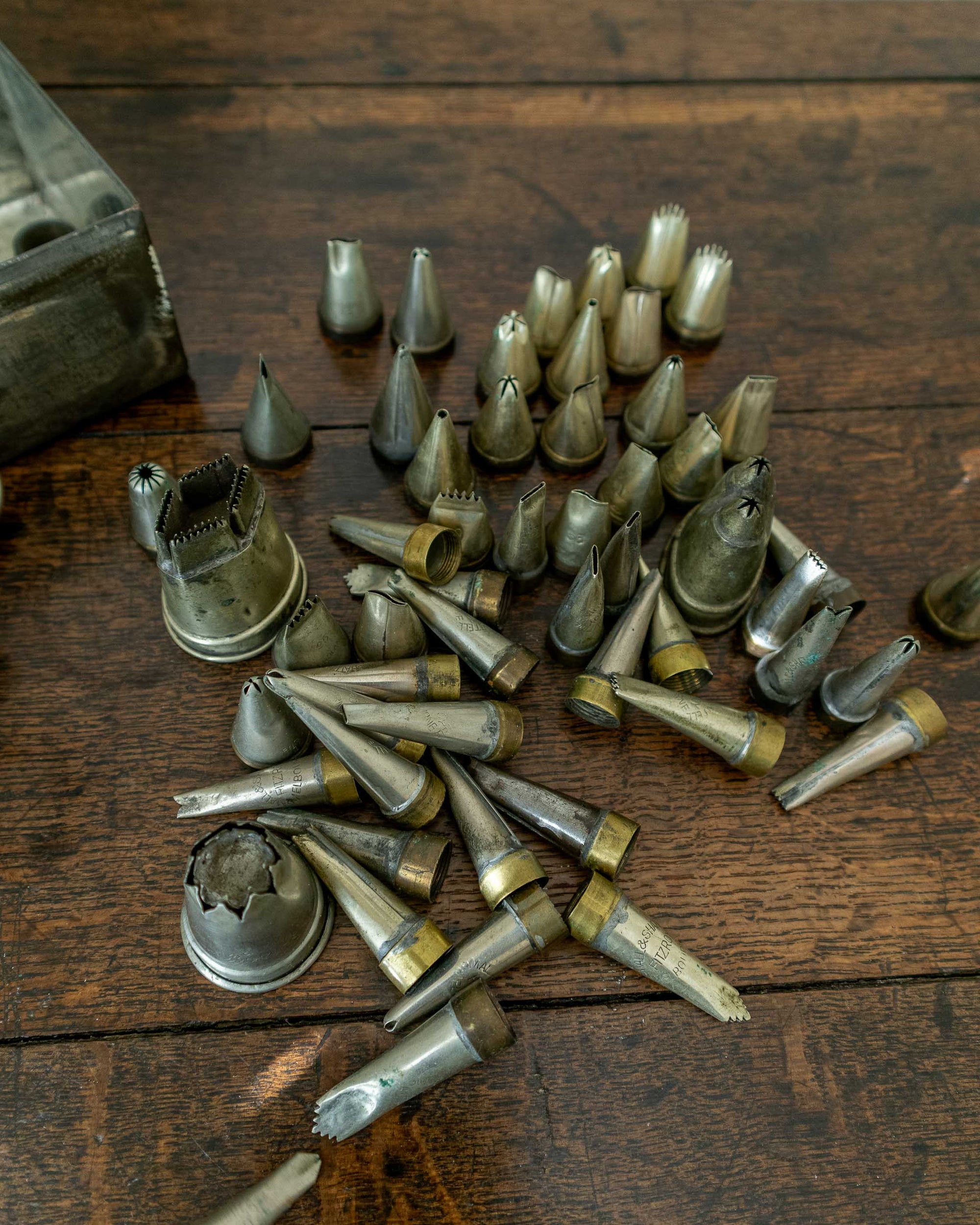 Collection of metal icing tips on a wooden surface