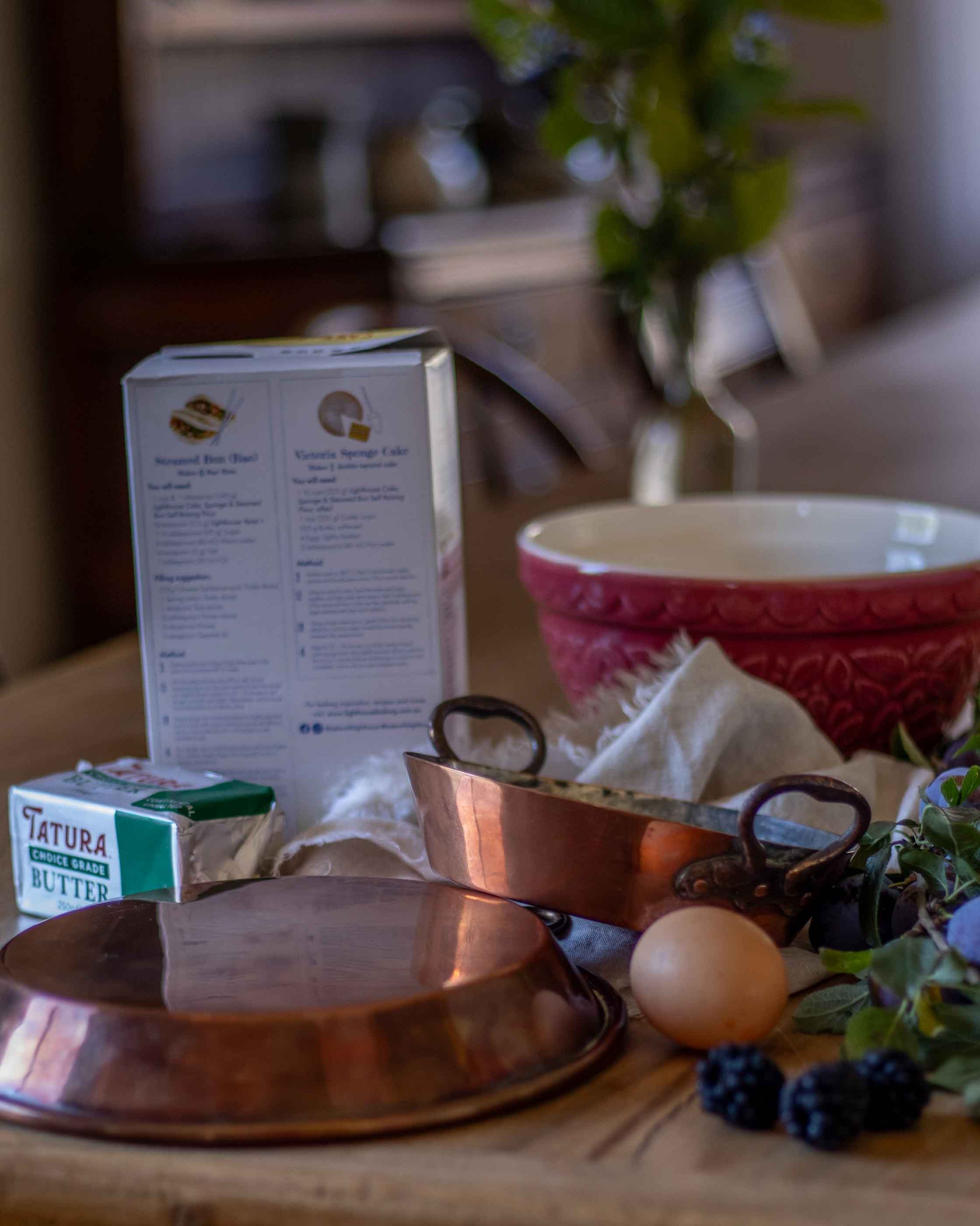 Copper kitchenware and ingredients on a wooden table with a blurred background