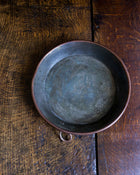 Copper pan on a wooden surface