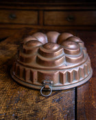 Copper bundt cake mould on a wooden surface