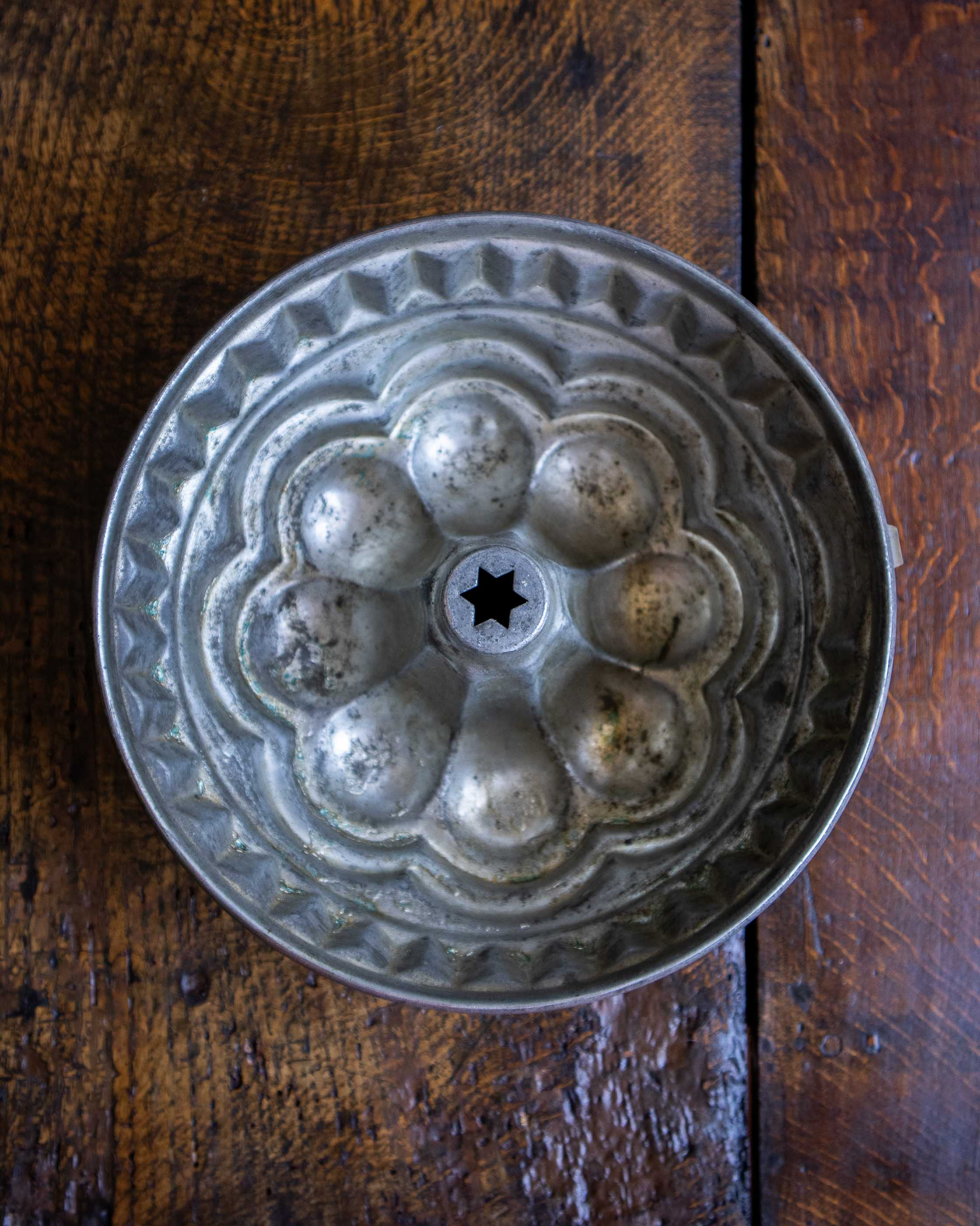 Copper bundt cake mold on a wooden surface