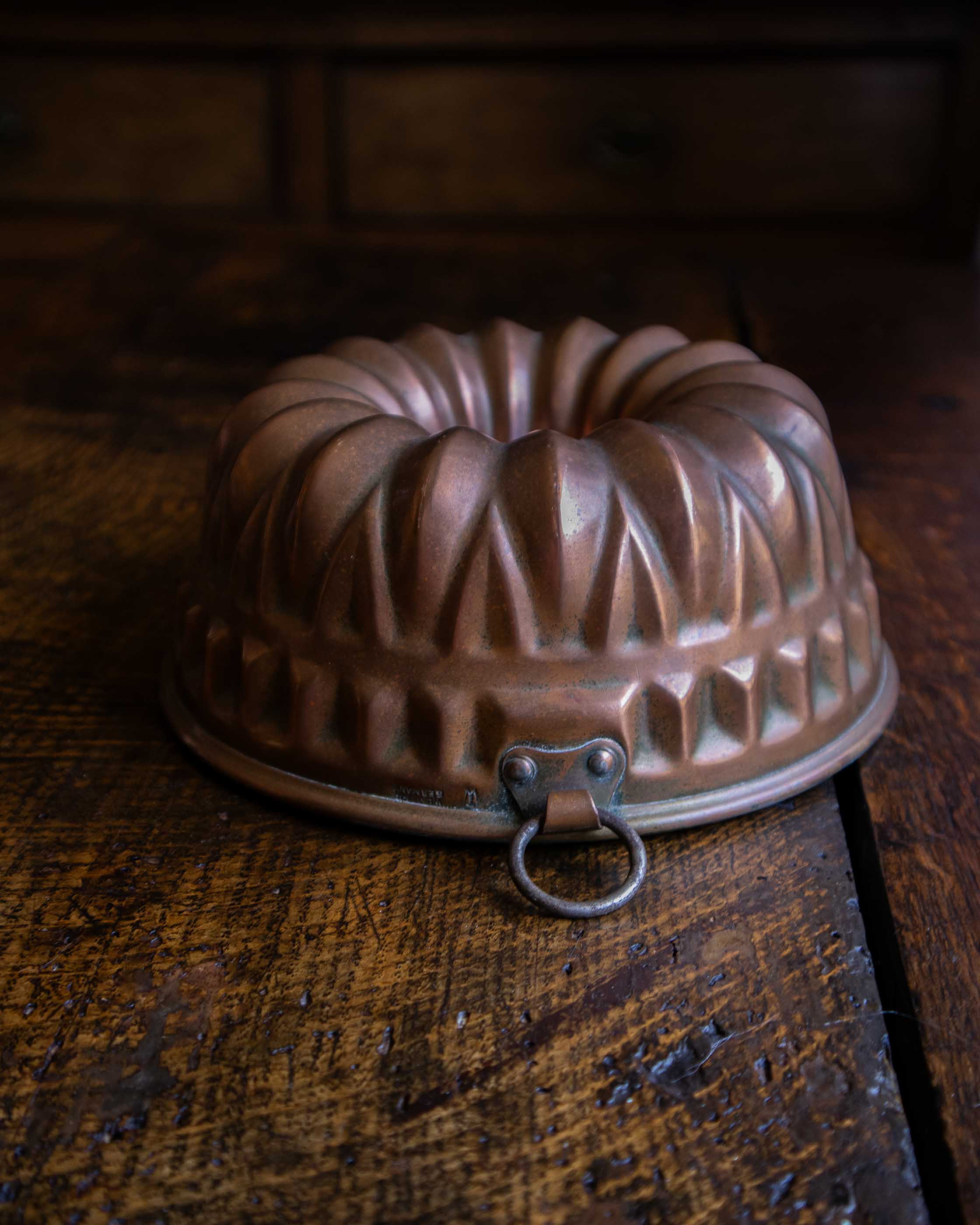 Copper bundt cake mould on a wooden surface