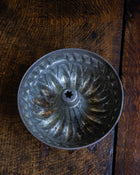 Copper bundt cake mould on a wooden surface