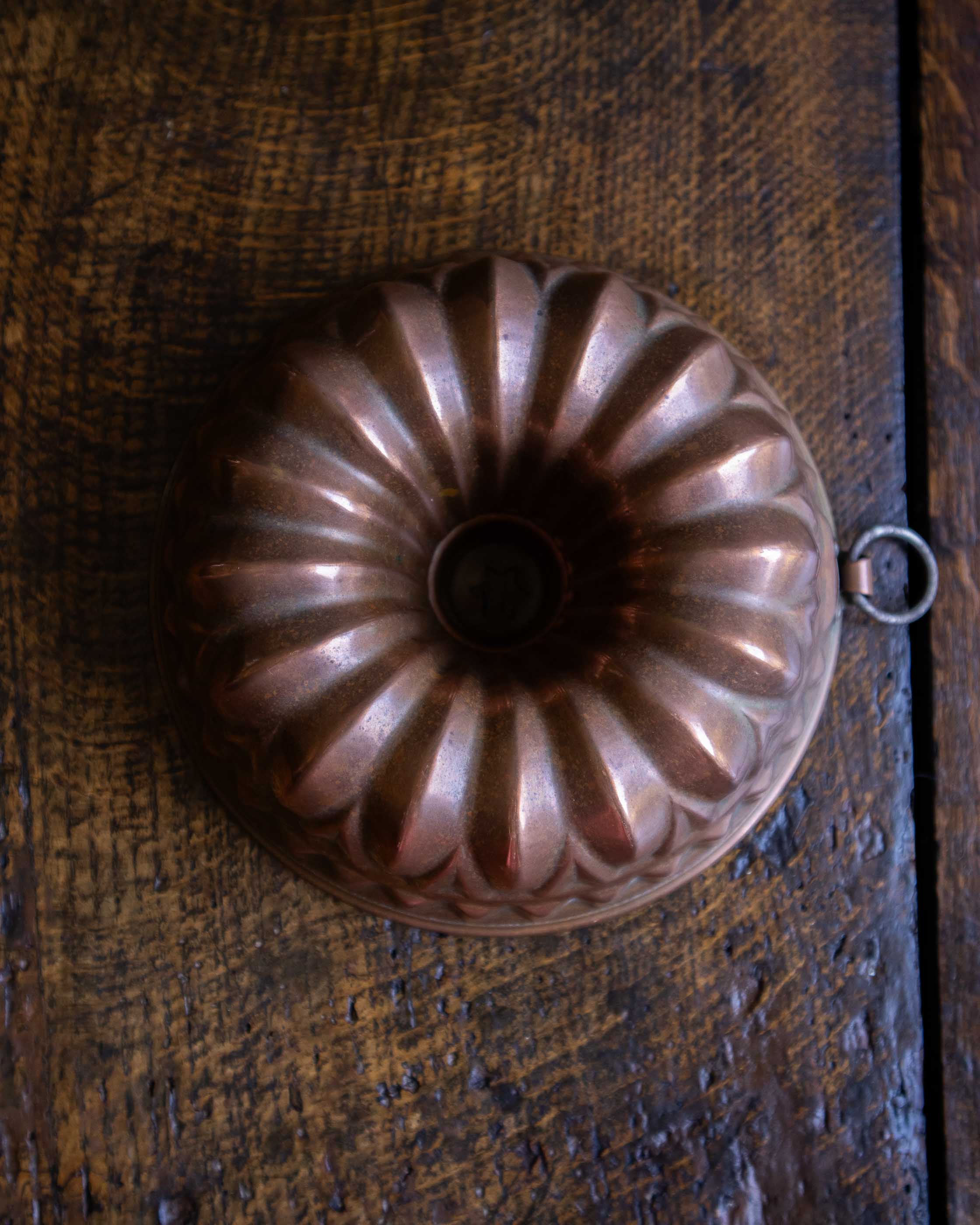 Copper bundt cake mould on a wooden surface