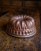 Copper bundt cake mould on a wooden surface