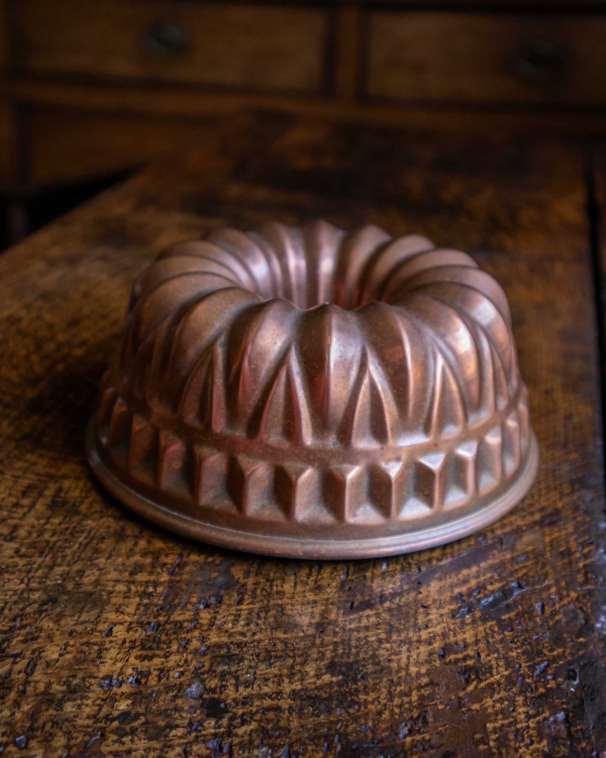 Copper bundt cake mould on a wooden surface