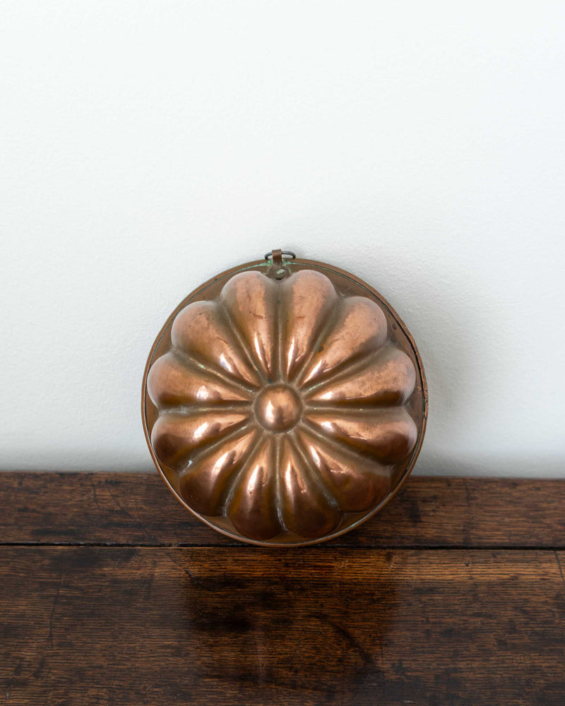 Copper mould on a wooden surface with a white background