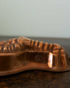 Copper mold with a textured surface on a wooden surface