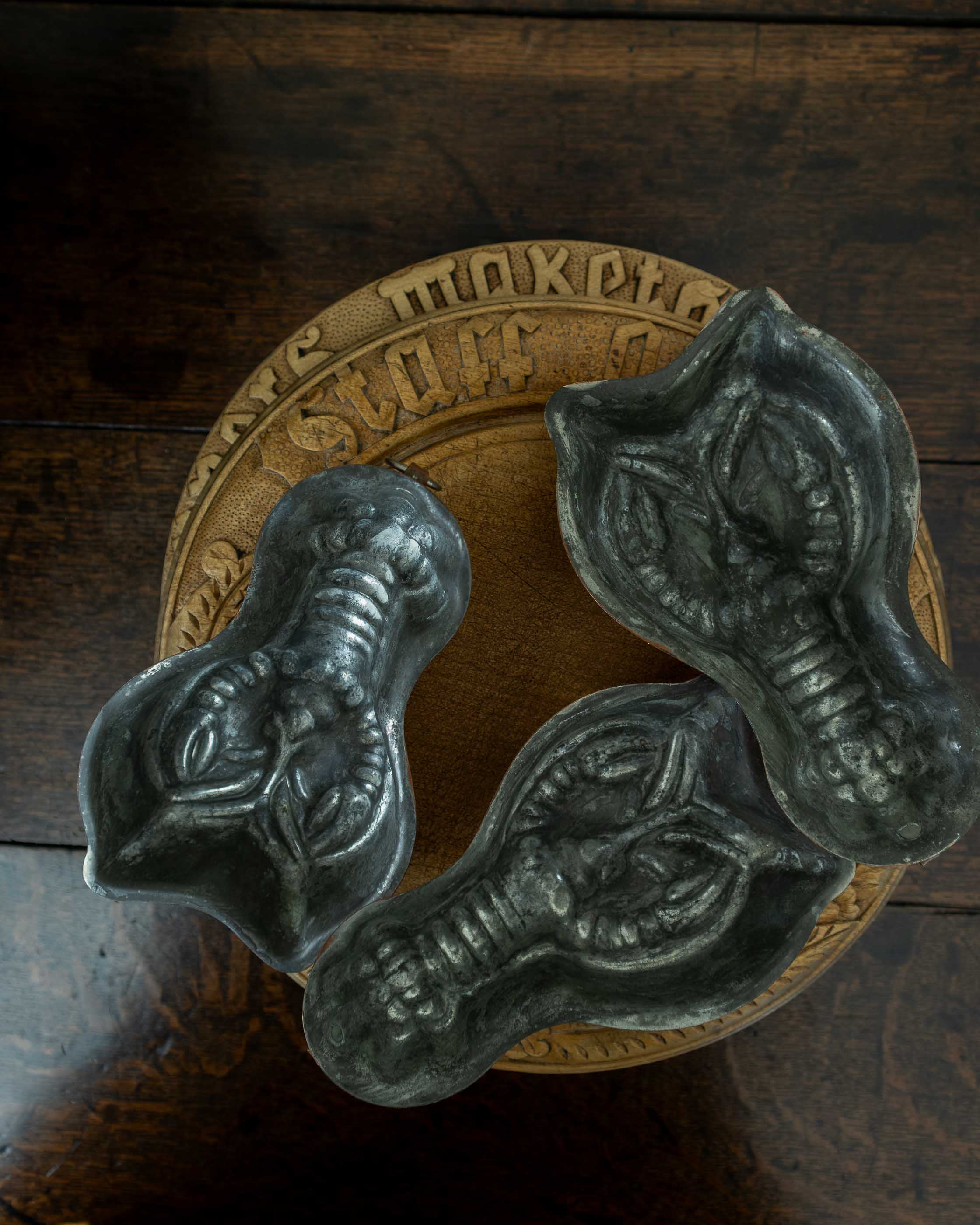 Decorative copper lobster moulds on a wooden surface