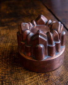 Copper mould with geometric design on a wooden surface