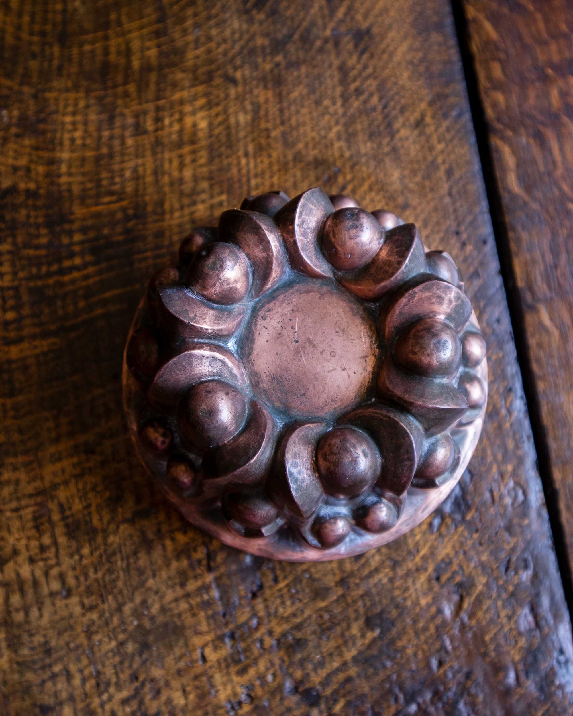 Decorative copper jelly mould on a wooden surface