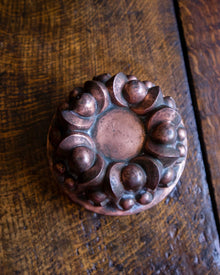Decorative copper jelly mould on a wooden surface