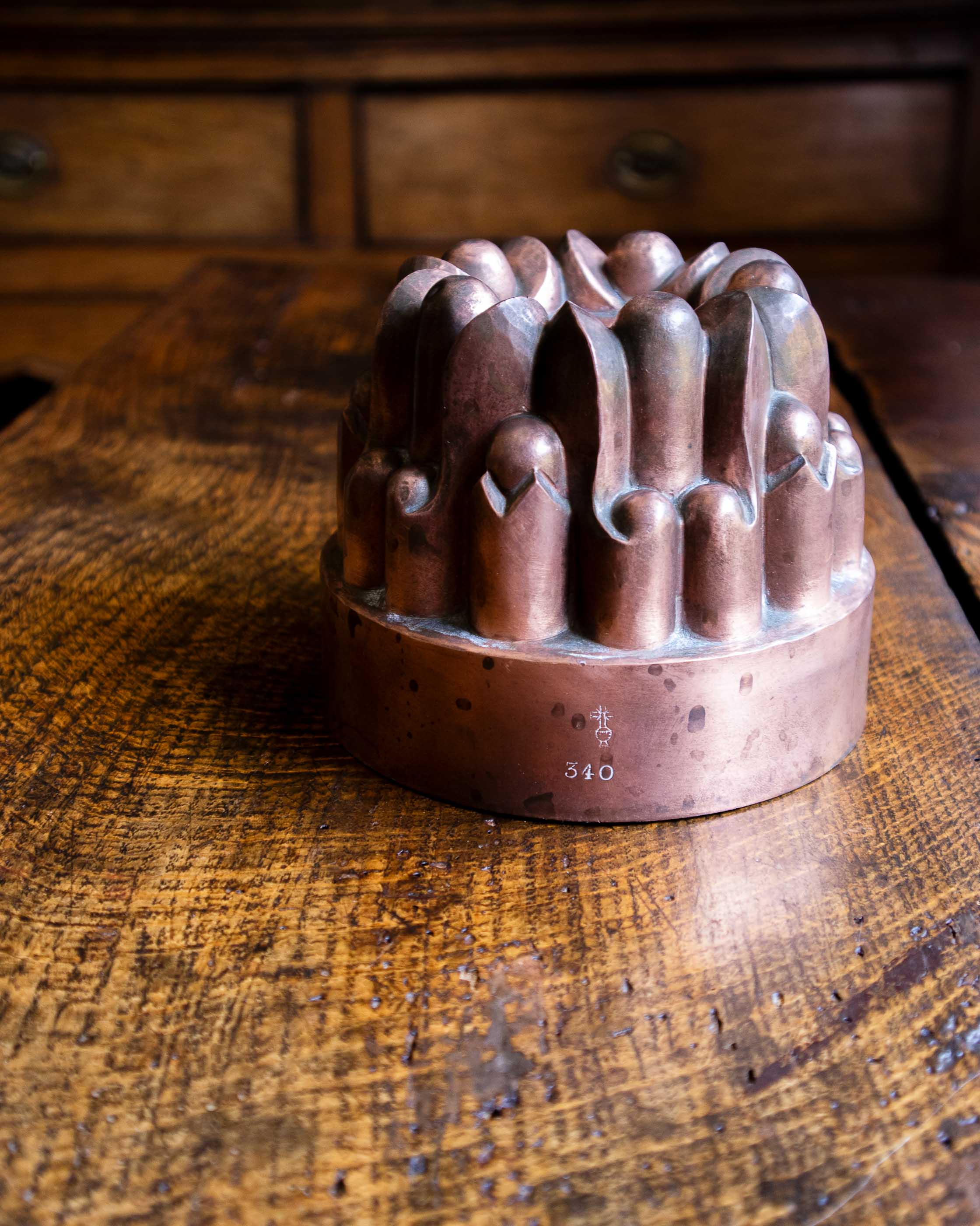 Decorative copper jelly mould on a wooden surface
