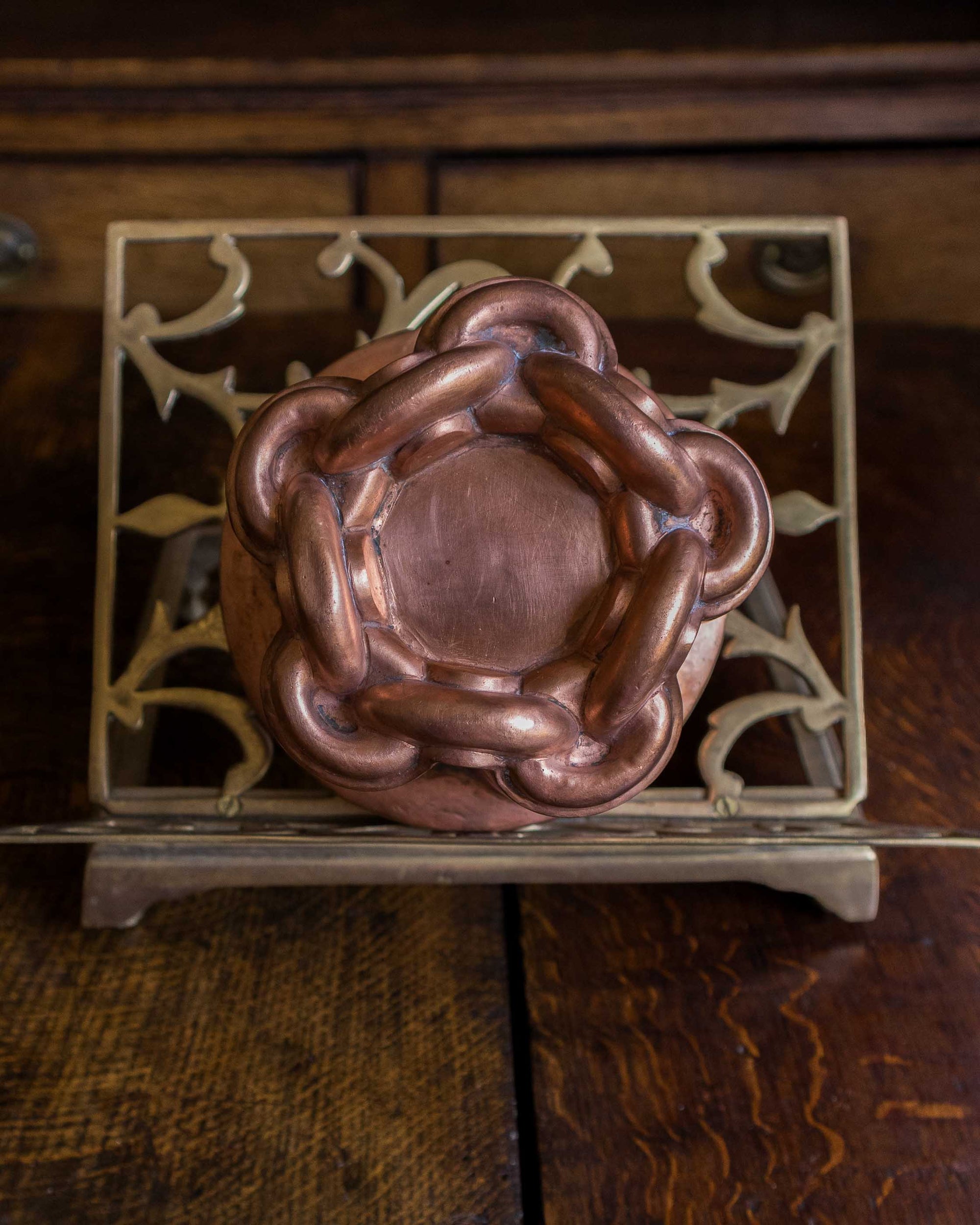 Copper mould on a decorative metal stand with a wooden background