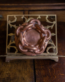 Copper mould on a decorative metal stand with a wooden background