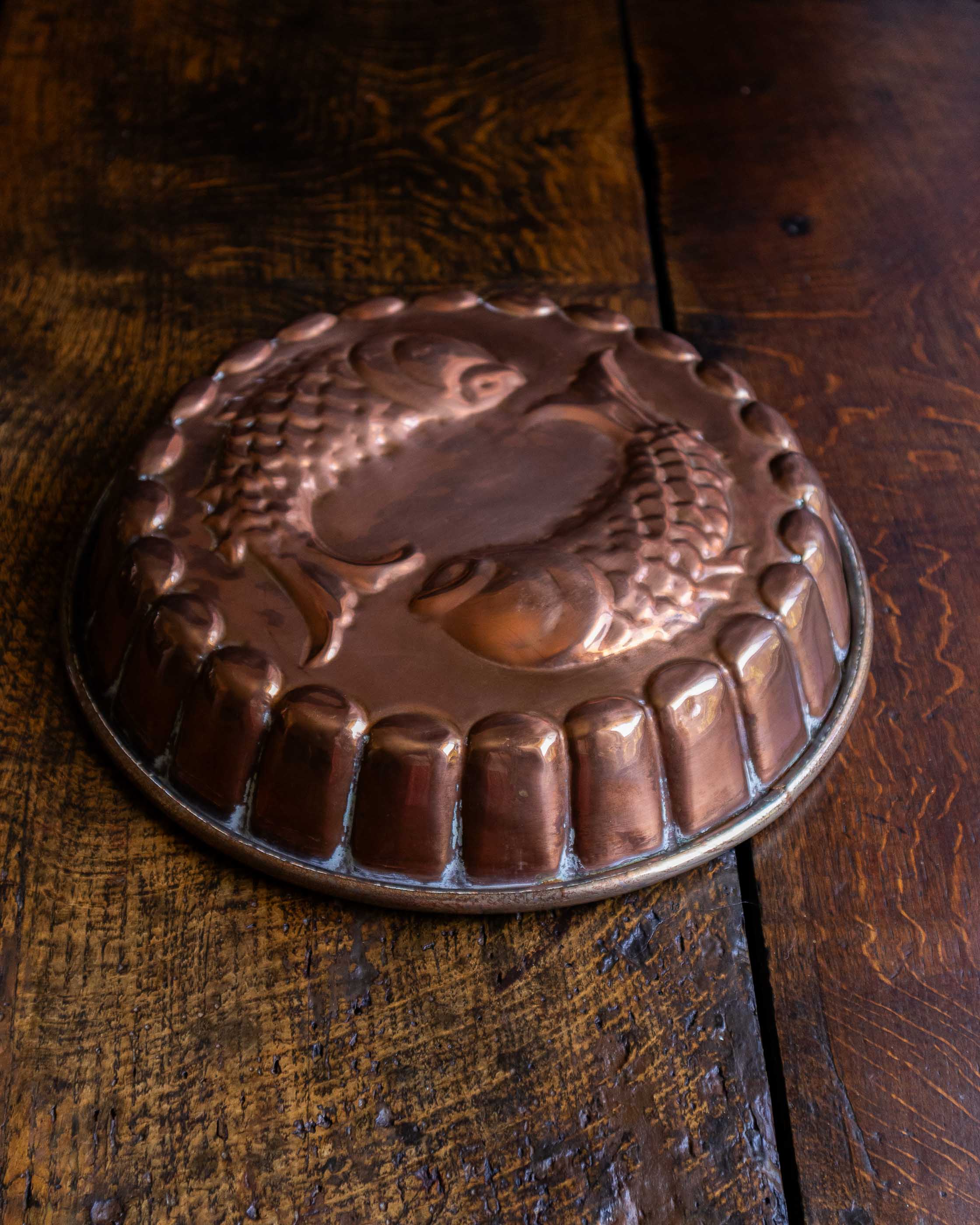 Copper mould with decorative design on a wooden surface