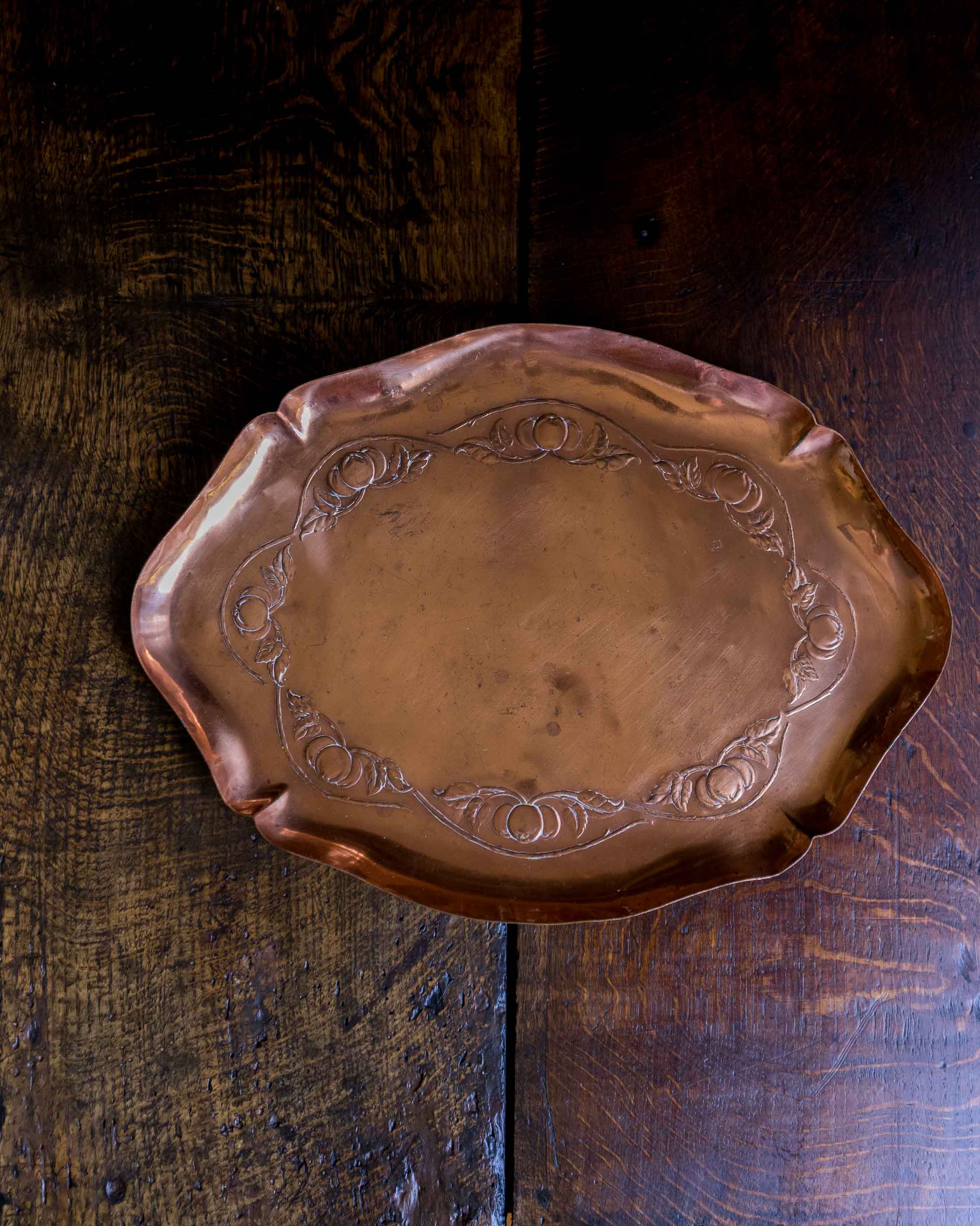 Decorative copper tray on a wooden surface