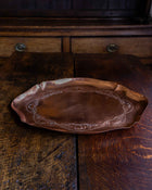 Decorative copper tray on a rustic wooden surface