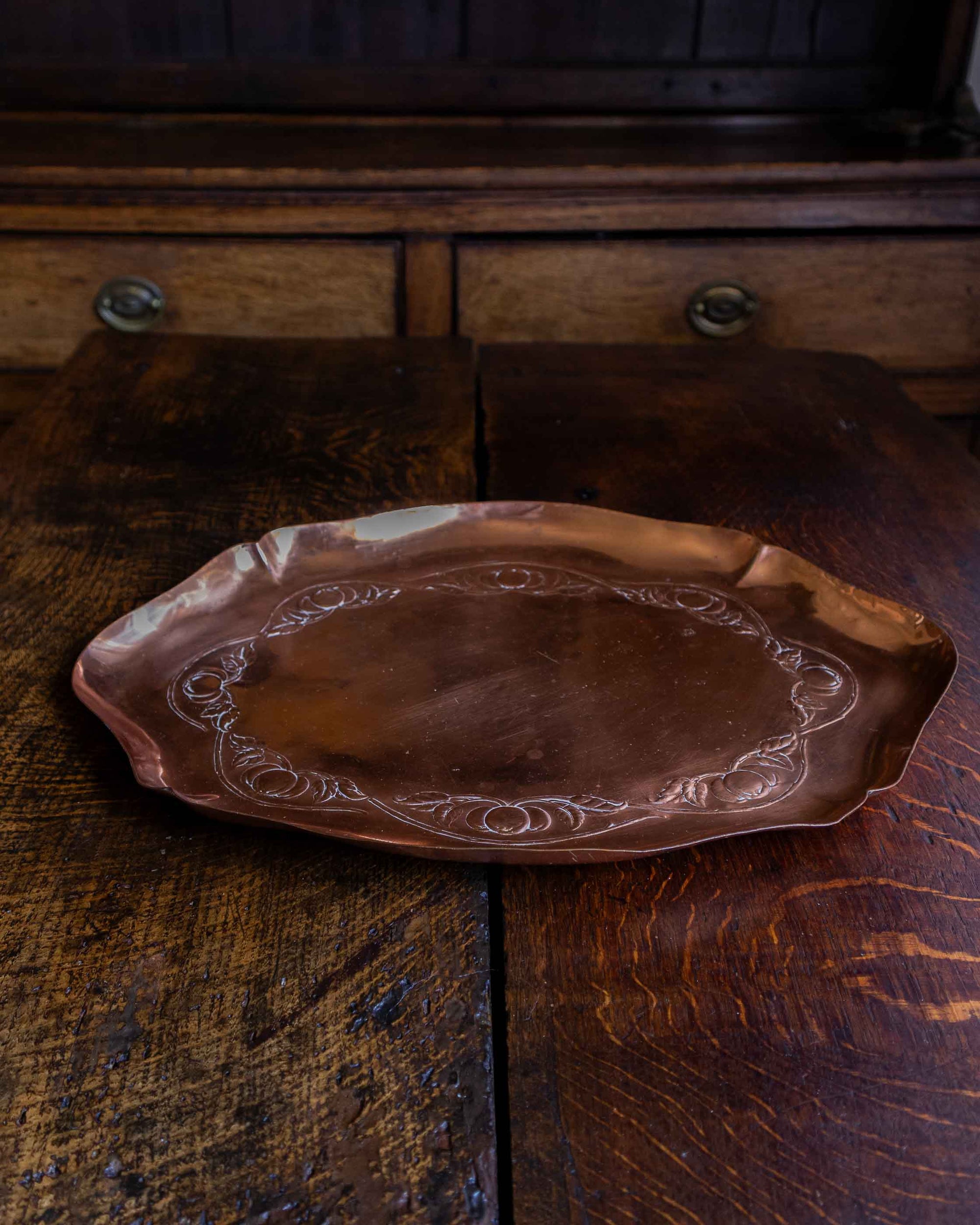Decorative copper tray on a rustic wooden surface