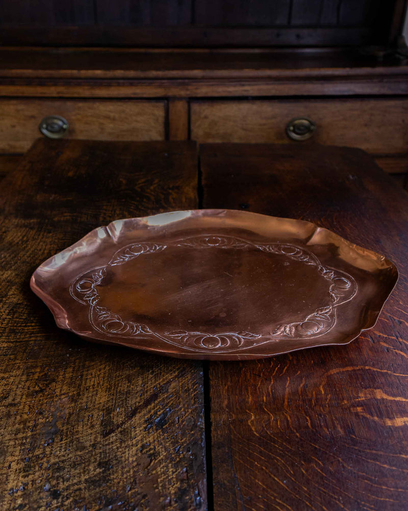Decorative copper tray on a rustic wooden surface